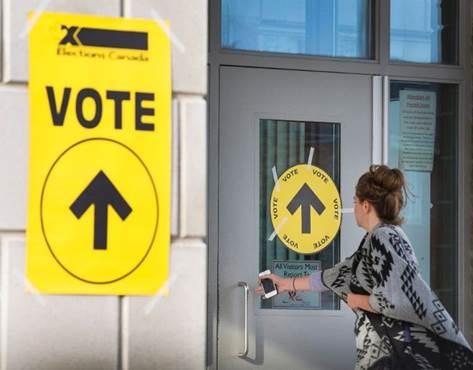 A woman enters Maple High School in Vaughan, Ont., to cast her vote in the federal election on Monday, Oct. 19, 2015. The summer political season is one usually spent far away from Ottawa, but this year a group of MPs has been gathering for meetings of the special committee on electoral reform to hear from expert witnesses on how and whether they should, change the way Canadians cast their federal election ballots. THE CANADIAN PRESS/Peter Power